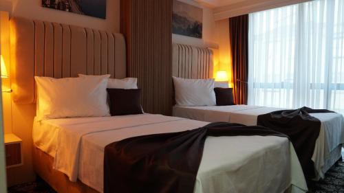 a hotel room with two beds and a window at Karadeniz Hotel Çorlu in Corlu
