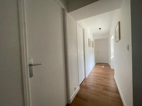 an empty hallway with a white door and wood floors at La Simone in Richerenches