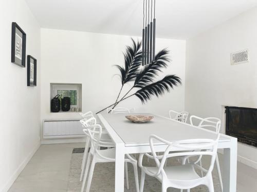 a white dining room with a white table and chairs at La Simone in Richerenches