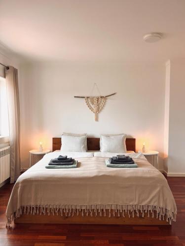 a bedroom with a large white bed with two tables at Casa 33 - Idyllisches Reihenhaus mit Innenhof in São Martinho do Porto