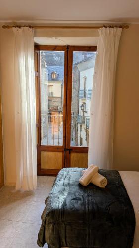a bed in a room with a large window at Hotel Fonda Agusti in Esterri d'Àneu