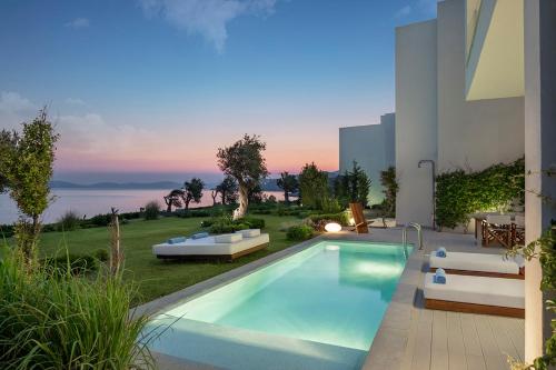 a villa with a swimming pool and a house at Susona Bodrum, LXR Hotels & Resorts in Torba