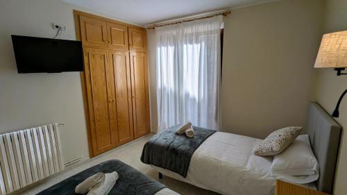 a bedroom with a bed and a couch and a television at Hotel Fonda Agusti in Esterri d'Àneu