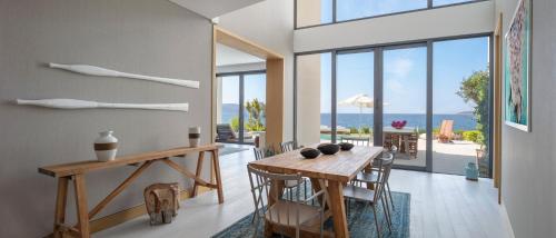 a dining room with a table and chairs with a view of the ocean at Susona Bodrum, LXR Hotels & Resorts in Torba