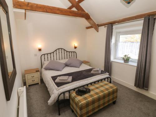 un dormitorio con una cama y una ventana en Mews Cottage, en Tintagel