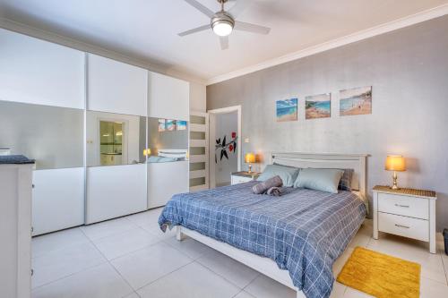 a bedroom with a bed with a blue blanket at La Casa Provenza in St Paul's Bay