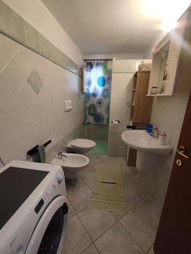 a bathroom with two sinks and a washing machine at Appartamento Meduse in Cala Gonone