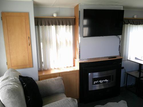 a living room with a couch and a flat screen tv at Happy Days South Chapel st leonards Sahara 4 Berth in Chapel Saint Leonards