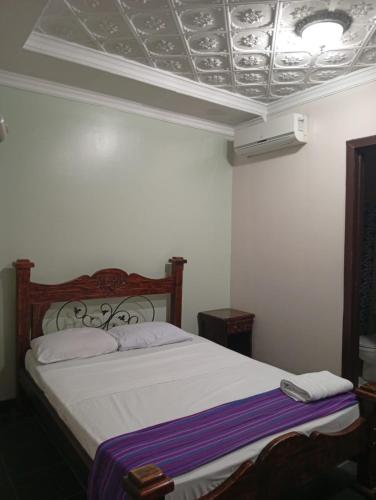 a bedroom with a bed and a coffered ceiling at Hotel el Tucan Alajuela in Alajuela City