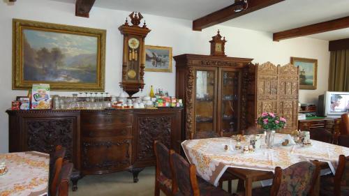 une salle à manger avec une table et une horloge murale dans l'établissement Pension Dana, à Vrbno pod Pradědem