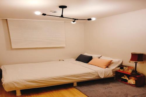 a bedroom with a bed and a ceiling at Hongdae 3mins, Q House in Seoul