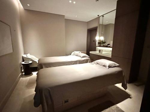 a hotel room with two beds and a mirror at Address Beach Resort Properties Bahrain in Manama