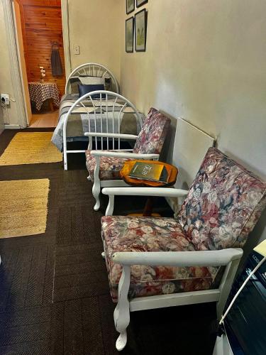 a room with three chairs and a couch and a bed at Glen House in Brenton-on-Sea