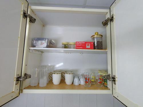 a cabinet filled with glass jars and other items at Ajman Family AIDEN Premium VIP in Ajman 