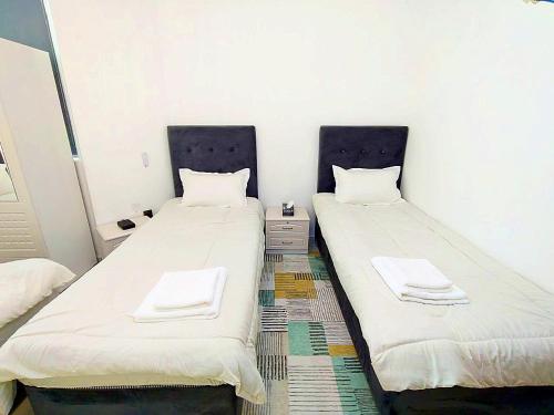 two beds sitting next to each other in a room at Ajman Family AIDEN Premium VIP in Ajman 