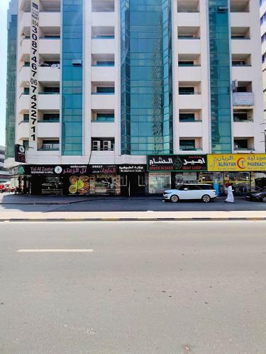a white car parked in front of a tall building at Ajman Family AIDEN Premium VIP in Ajman 
