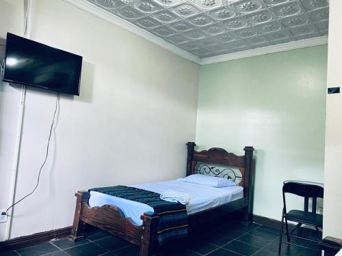 a bedroom with a bed and a flat screen tv at Hotel el Tucan Alajuela in Alajuela City