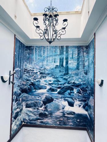 a wall mural of a forest with a waterfall at Hotel el Tucan Alajuela in Alajuela City