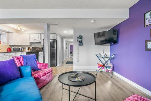 a living room with purple walls and a table at Modern 3 Bedroom Suite Near Downtown & Stampede Grounds in Calgary