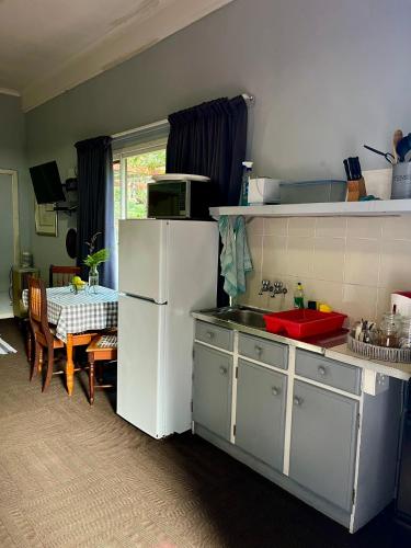 a kitchen with a white refrigerator and a table at Glen House in Brenton-on-Sea