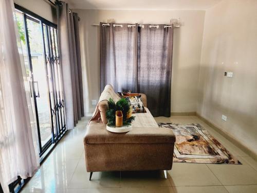 a living room with a couch and a window at Eastern Road Executive Suites in Harare