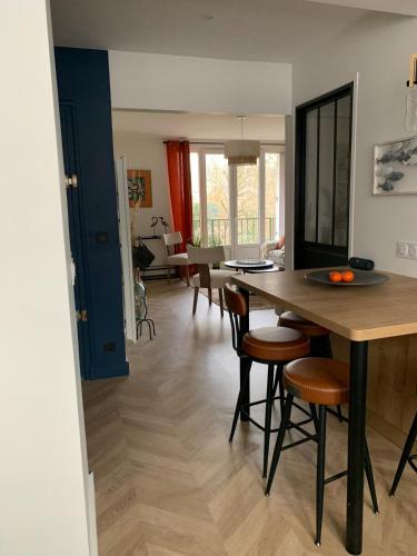 a kitchen and living room with a table and chairs at La fontaine à Chantilly in Chantilly