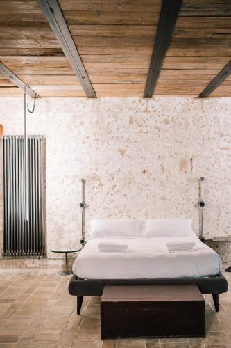a bed in a room with a brick wall at Il Granile Contemporary Loft in Matera
