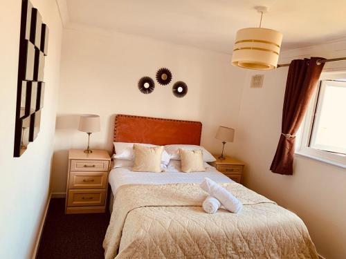 a bedroom with a bed and two lamps and a window at Home like 3 bed house Sheffield in Sheffield