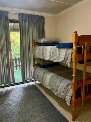 a bedroom with two bunk beds and a window at Glen House in Brenton-on-Sea