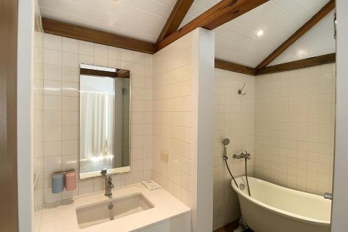 a bathroom with a sink and a bath tub at 初嶼Meet in Hengchun