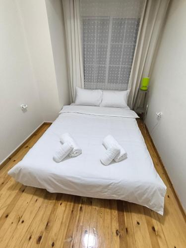 a bed with two slippers on it in a room at Cozy Houses One in Kavala