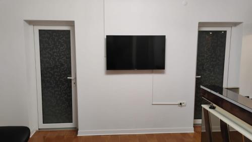 a living room with a flat screen tv on a white wall at Casa de vacanta in Geoagiu Băi