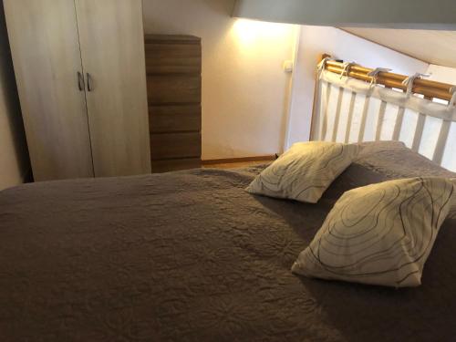 une chambre avec un lit avec deux oreillers dessus dans l'établissement Le Soleil - Mazet 33, à Saint-Martin-de-Brômes