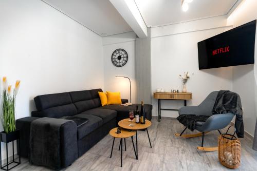 a living room with a black couch and a table at AcroLofts M62 in Athens