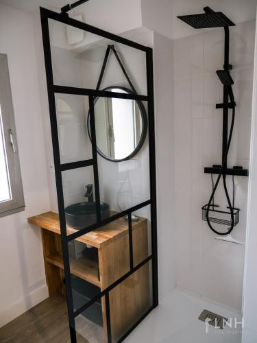 une salle de bain avec un miroir et un lavabo dans l'établissement L'appartement de jeanne, à Quimper
