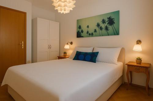 a bedroom with a large white bed and two lamps at Apartman Ivanto in Makarska