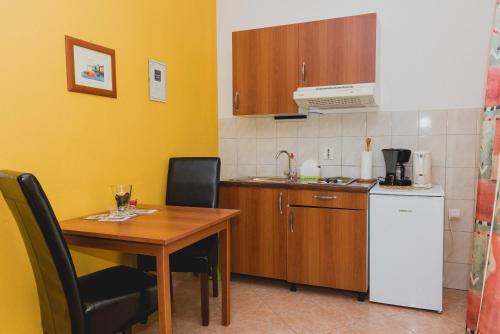 a kitchen with a table and a small kitchen with a table and chairs at Apartments Lovrić in Vodice