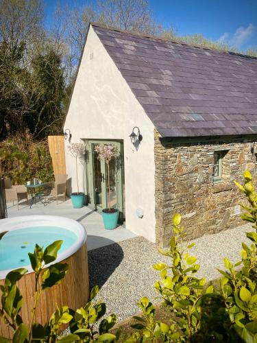 a small building with a tub in the yard at Foxglove Cottage in Béal an dá Chab