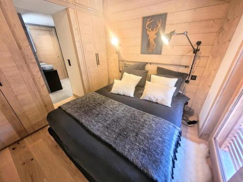 une chambre avec un lit dans une pièce aux murs en bois dans l'établissement Résidence Le Stella - Elégance et confort au coeur du village MAE-1031, aux Gets