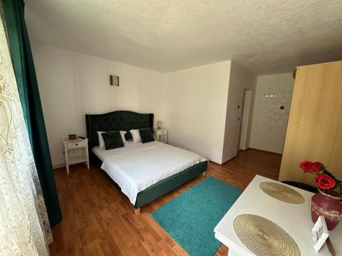a small bedroom with a bed and a table at VILA ANA in Băile Herculane