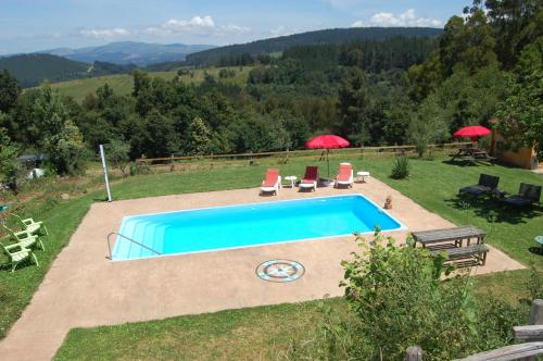 a swimming pool with two chairs and two umbrellas at Nuevo sabor rural Ribeira Sacra in A Pobra do Brollon