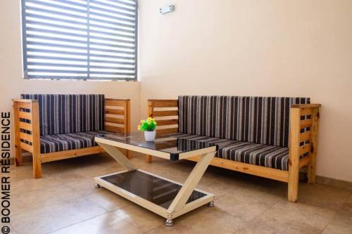 a living room with two couches and a table at Boomer Résidence in Abomey-Calavi