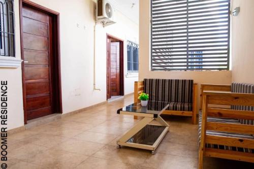 a living room with a glass table and a door at Boomer Résidence in Abomey-Calavi