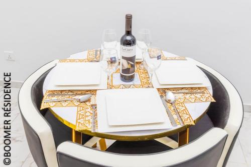 a table with a bottle of wine and a glass at Boomer Résidence in Abomey-Calavi
