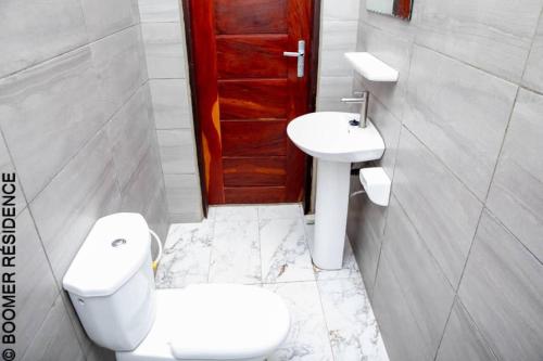 a bathroom with a toilet and a sink at Boomer Résidence in Abomey-Calavi