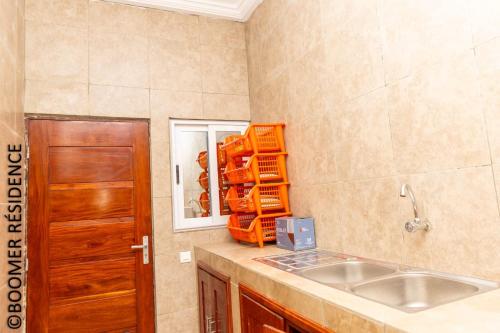 a kitchen with a sink and a mirror at Boomer Résidence in Abomey-Calavi