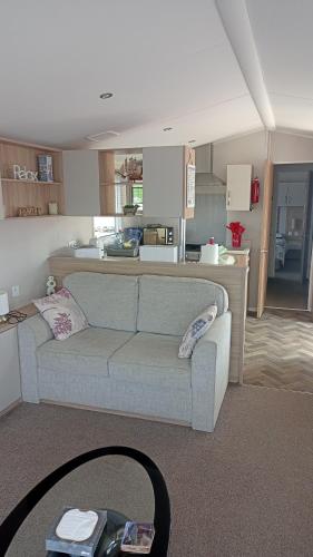 a living room with a couch and a kitchen at Margaret's in Wool