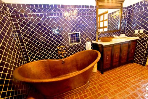 a bathroom with a wooden tub and a sink at Guayaba Inn Boutique Hotel in San Cristóbal de Las Casas