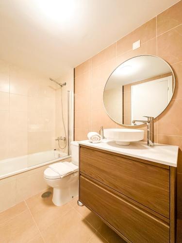 a bathroom with a sink and a mirror and a toilet at Apartamento Nautilus by ALÔGA in Fisterra