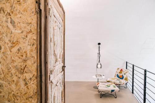 an open door leading into a room with a chair and a table at Il Granile Contemporary Loft in Matera